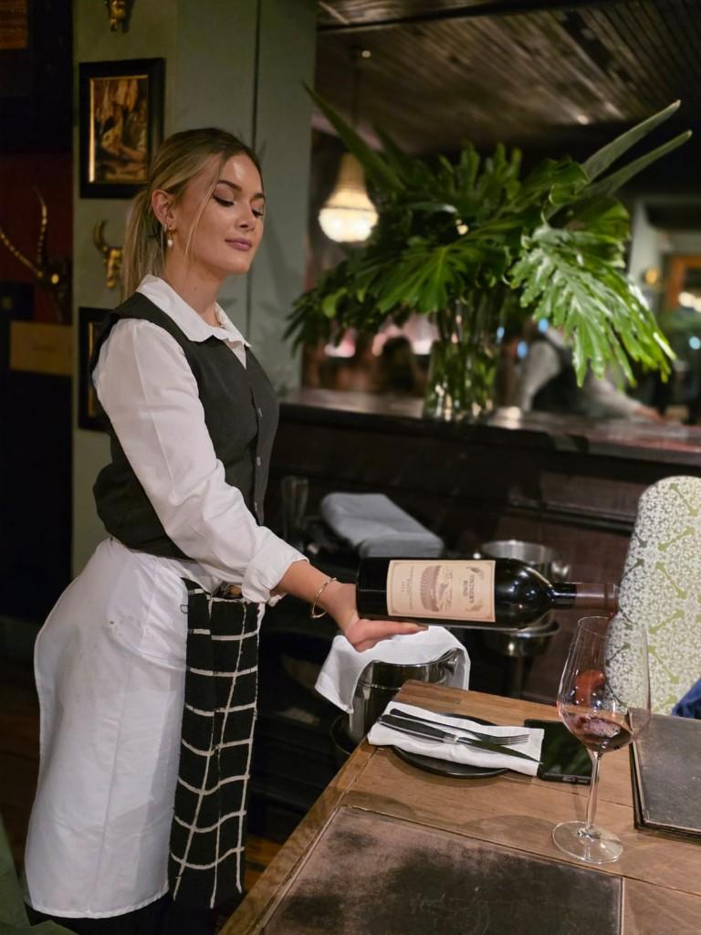 Sommelier pouring Vintner's Bond red wine